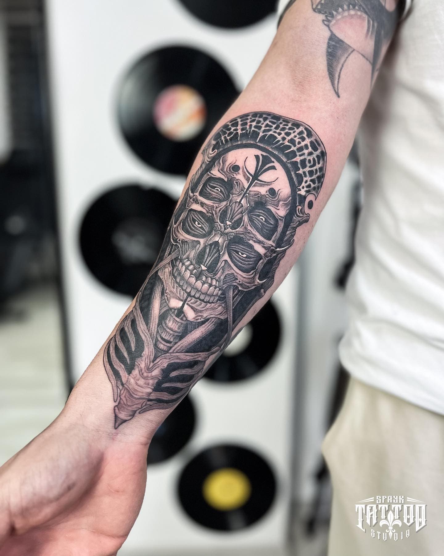 Surreal multi-eyed skull blackwork forearm tattoo