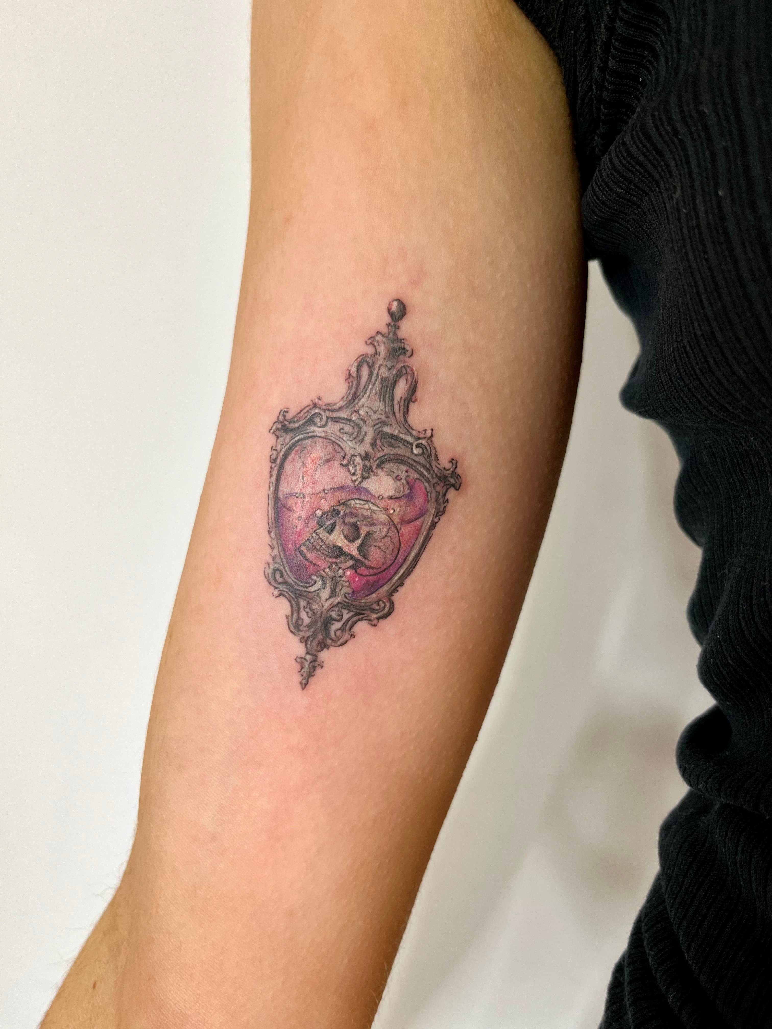 Ornate skull in pink vessel forearm tattoo