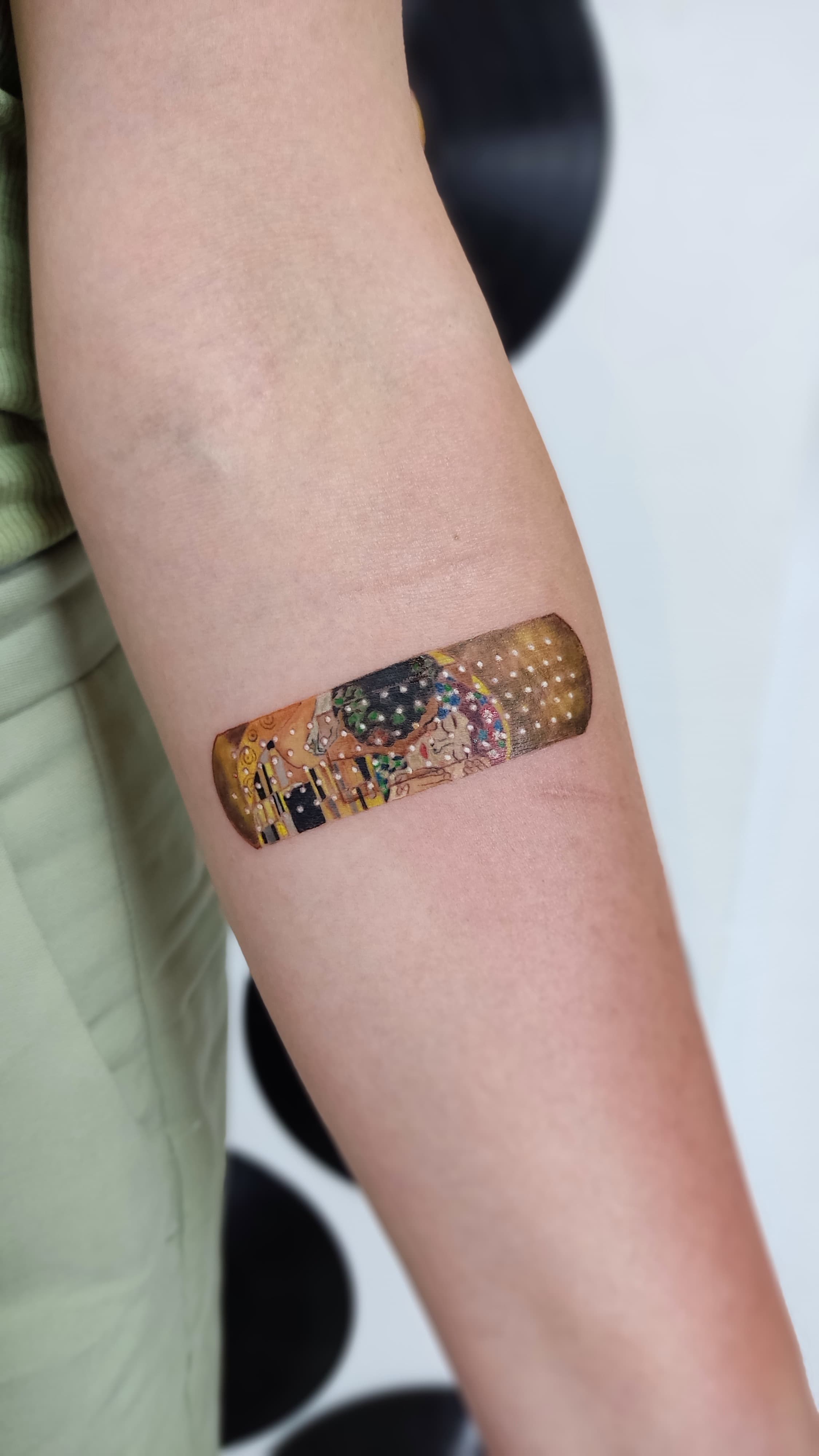 The Kiss band-aid forearm tattoo in color realism
